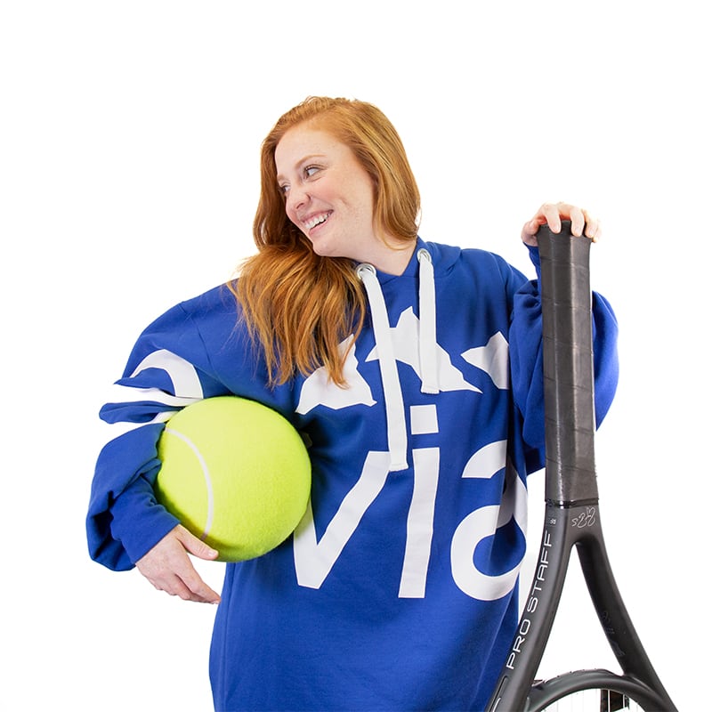 woman holding giant tennis racquet and tennis ball
