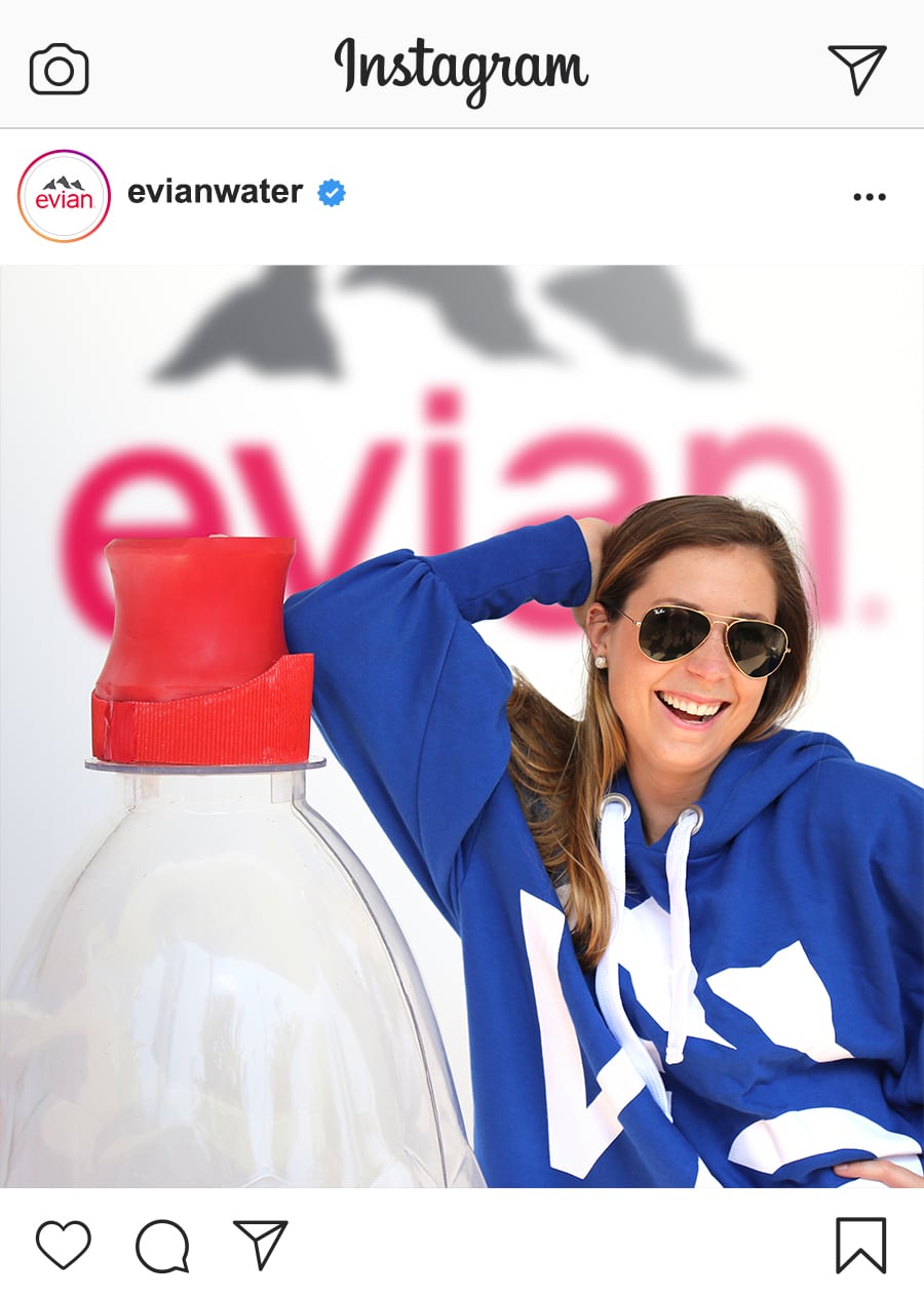 woman leaning on giant evian bottle at the us open