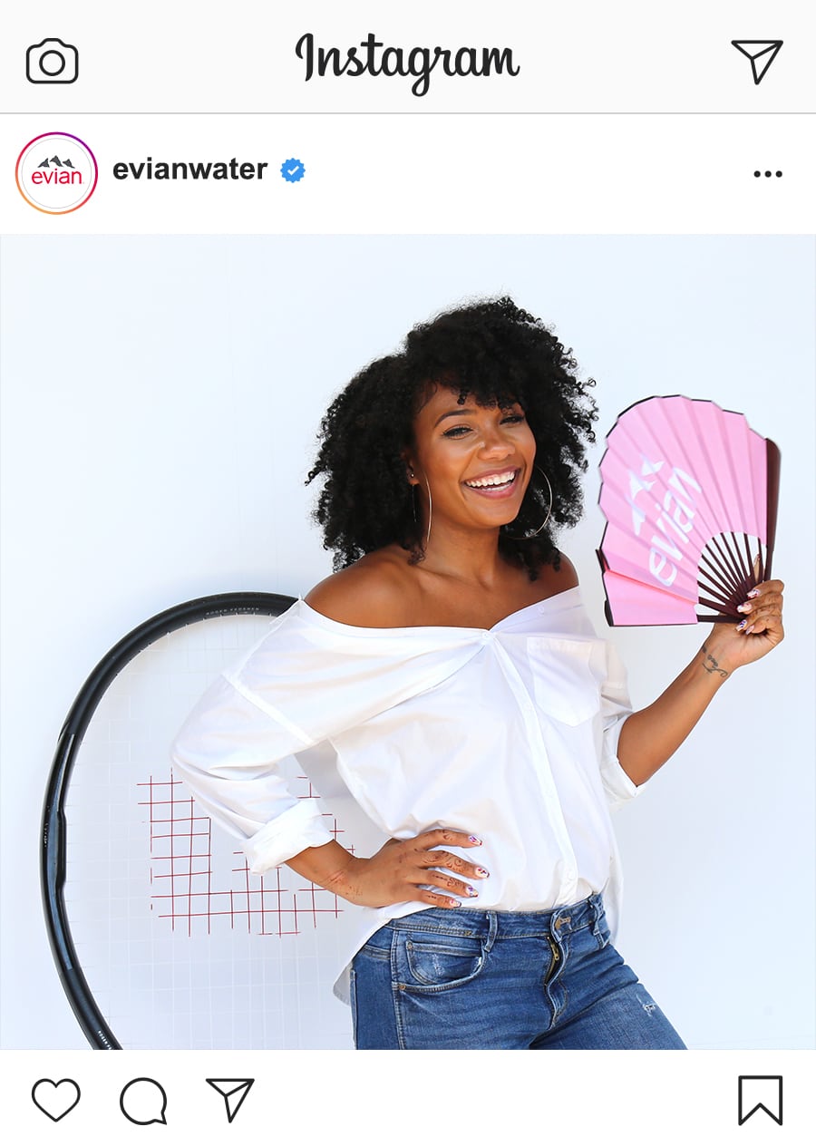 woman holding evian fan and giant tennis racquet