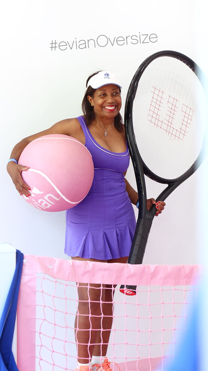 woman holding oversized evian racquet and ball